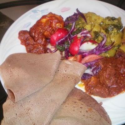 Ethiopian Cuisine: Enjera (Ethiopian fermented flat bread made from teff only) on side red lentil  curry veggie...t