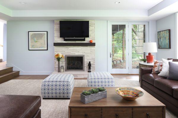 The new fireplace is clad with stacked stone in neutral tones; the walls, ceiling and trim in Sherwin Williams 6246 North Star.