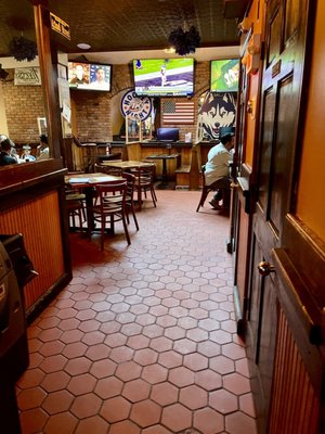 Hallway past bar with restrooms and seating in back