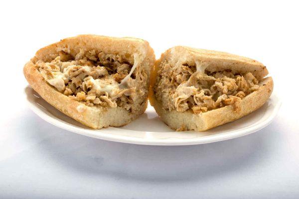 A mouthwatering chicken cheesesteak sandwich on a plate - Genova's To Go's specialty!