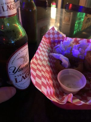 Bottle of yuengling and a patty melt with fresh onion rings.