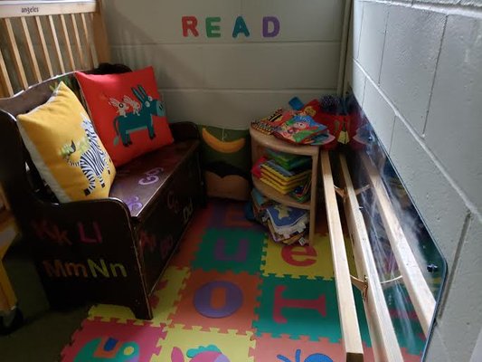 This cozy reading corner in the infant room includes a standing bar.