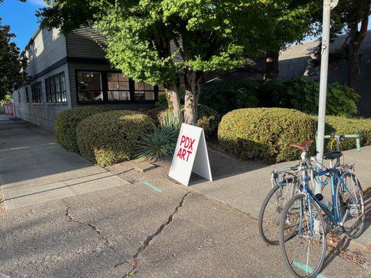 PDX art sidewalk sign and bicycles.