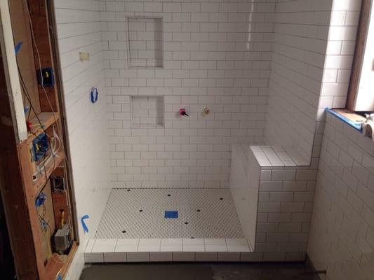 Custom built shower. Dal 3x6 subway. Hex floor and shower pan. Random black dots. In progress.