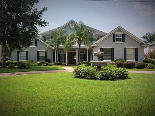 This modern house looks fabulous in grey, highlighted with white trim and black shutters, and really stands out from the landscaping.