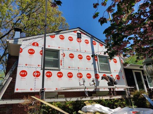 Fanfold insulation being installed under new siding on a home in Annapolis