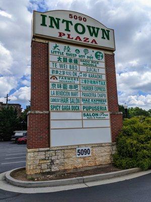 Intown Plaza street sign with list of tenants (retailers/restaurants) on Buford Highway.