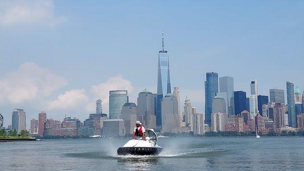 Hovercraft returning from a tour of the New York Bay area, Freedom Tower and cityscape behind.