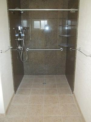 this is a handicap shower for a person in a wheelchair, done with granite walls and tile floor.with the shower pan being the fl