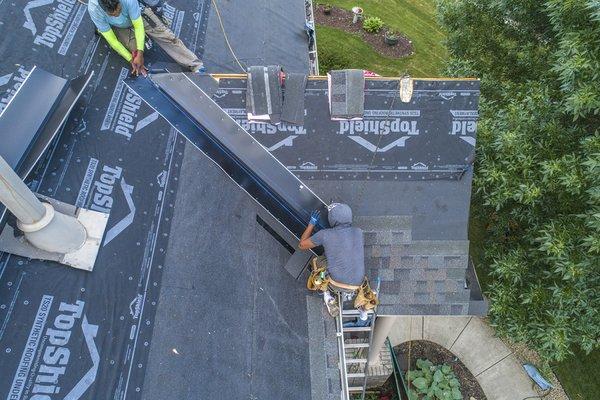 Roofing crew installing valley metal