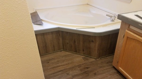 Vinyl Plank floor installed on face of bath tub.