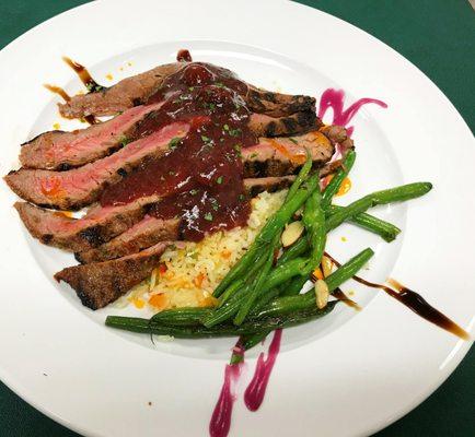 Grass fed Colorado bison flank steak chargrilled to order with rice pilaf with a side of almondine green beans. Cherry merlot reduction