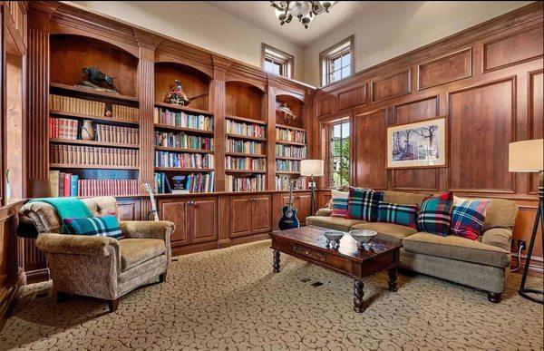 Alder study with arched top bookcases, fluted columns and paneling details.