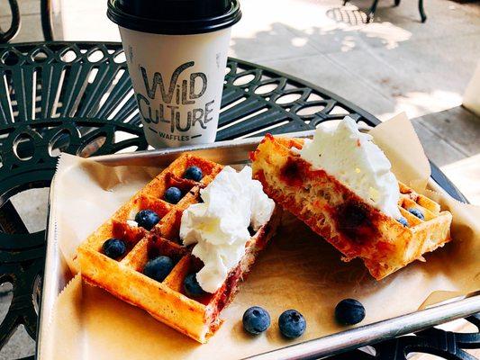 cross section of jam-stuffed waffle with whipped cream and fresh blueberries