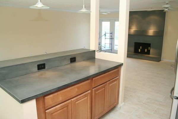 Cool Grey Concrete Countertop with a matching Concrete Fireplace Surround