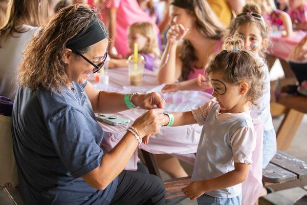 Mom putting bracelet on daughter during "girls day out"