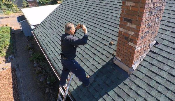 Tom Brick inspecting a chimney on a house