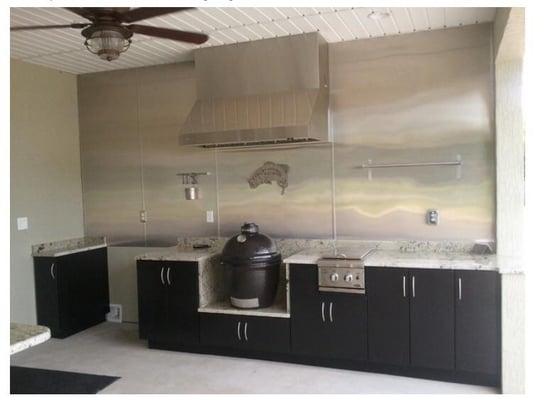 Custom outdoor kitchen featuring a stainless steel  backsplash