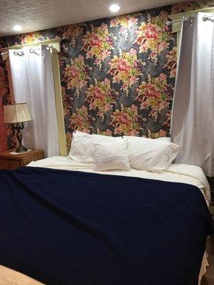 King sized bed with funky wallpaper