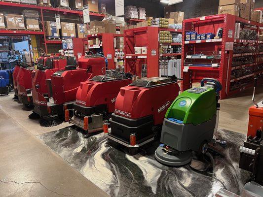 Rows of floor scrubbers in front of shelves with carpet cleaning supplies at Jon-Don Denver