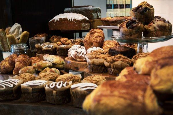 Table of pastries, muffins, bread, croissants.