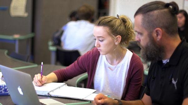 Student being tutored in a classroom.