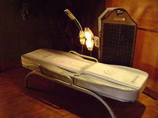 Migun Massage Energy Bed with heated jade stone infra-red heads massaging up and down your full body as you lie fully-clothed, face-up.