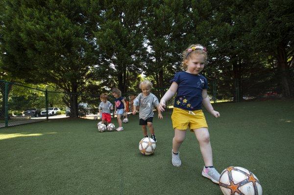 Children dribblind their soccer balls on Soccer Island.