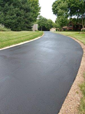 Not a quick spray job!  Perfectly hot crack filled and sealcoating driveway.