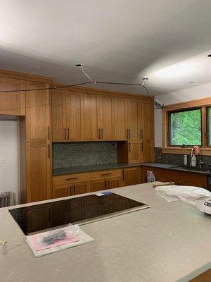 Surrounding quartz counters, tile backsplash, and island