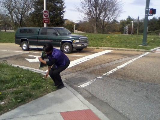 H&R Block representative placing sign in public space at Cary Street and the exit ramp (Thompson Street intersection) of the Powhite Pkwy.