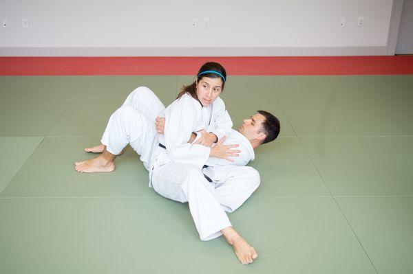 Sensei Katy Ancelet demonstrating mat work on Sensei Dimitri Papadopoulos