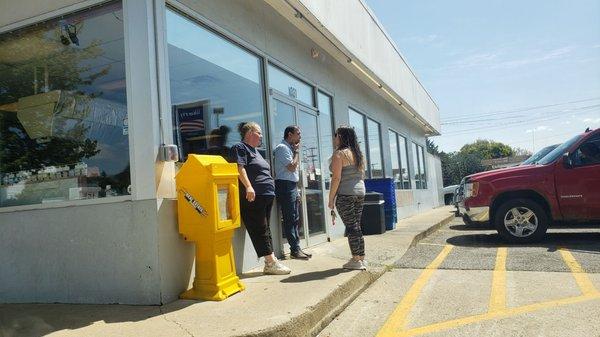 The clerks smoking by the pumps and front door.