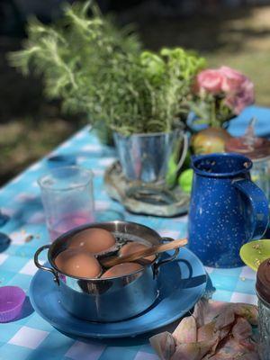 Faux eggs for mud kitchen play with fresh herbs.