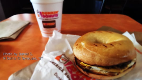 Medium coffee and bagel with egg, sausage, and cheese.