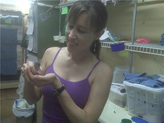 Jacky holding a baby bird while volunteering at Liberty Wildlife