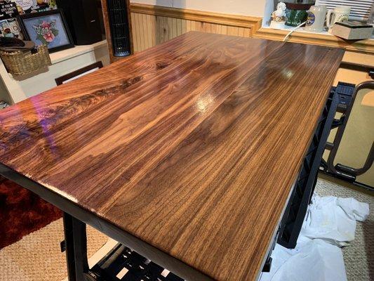 Slab walnut table mounted on powder coated custom welded legs.