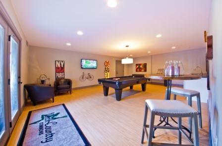 Game room with shuffle board table and pool table.