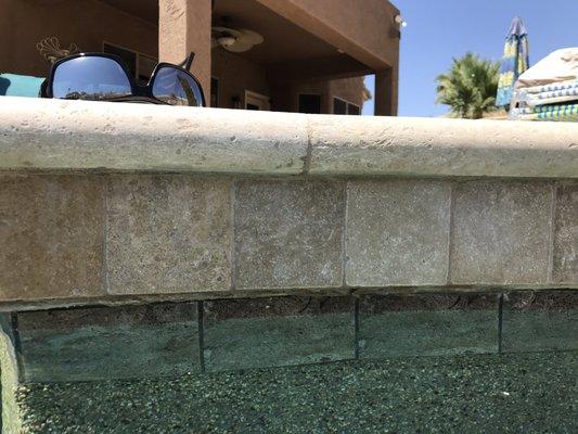 Exposed concrete between Travertine and pool tile