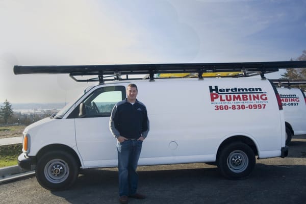 The owner, Adam Herdman, with the company vans.