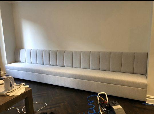 Custom wall to wall banquette on lucite toe kick