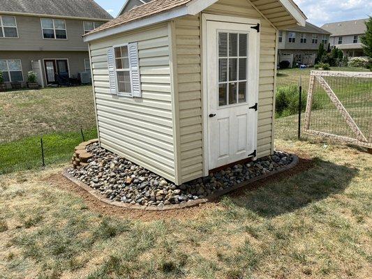 New stone edging around the shed to contain rocks.