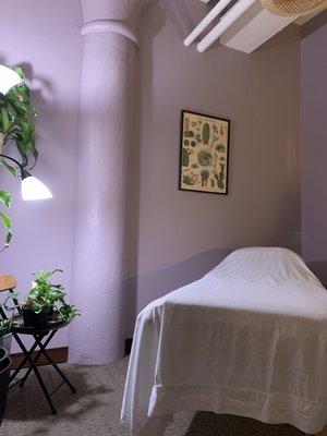 Treatment room with soft lighting, plants, high ceiling.