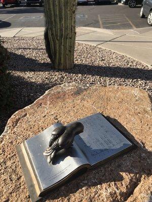 A bird (sculpture) reading a book.