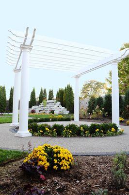 Our pergola with a beautiful landscape that includes a large stone waterfall