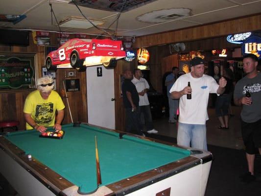 Pool table with a cute lamp.