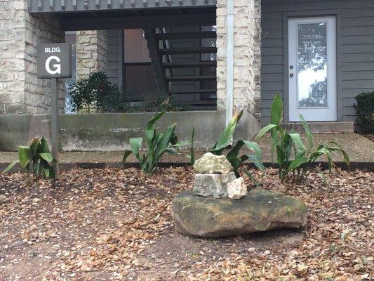 Building G is the only one with rock cairns in front.