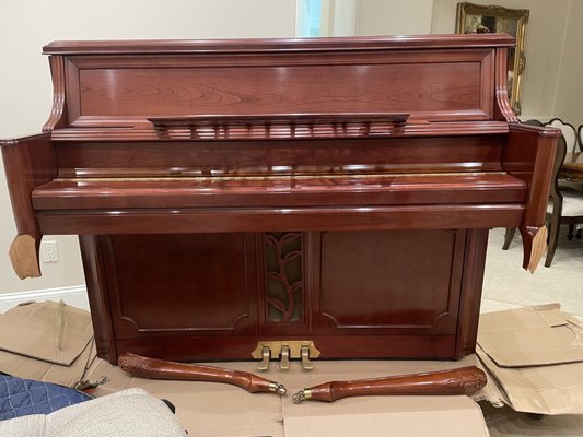 Another pic of the piano with the legs torn off & laying on the cardboard on the floor