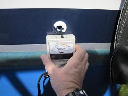 Moisture meter testing of a fiberglass hull in Fort Lauderdale, Florida www.marinesurveyorflorida.com