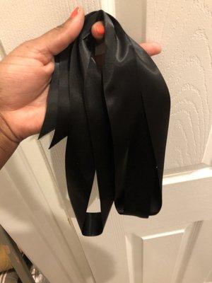 The black ribbon they gave my husband when he went back to get the back belt that came with my nice Ralph Lauren dress. This is not a belt.